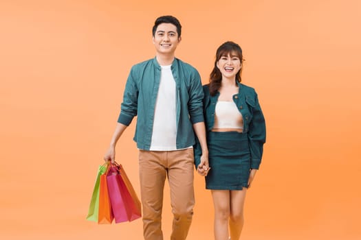 Happy couple with shopping bags, standing close to each other with smile. 