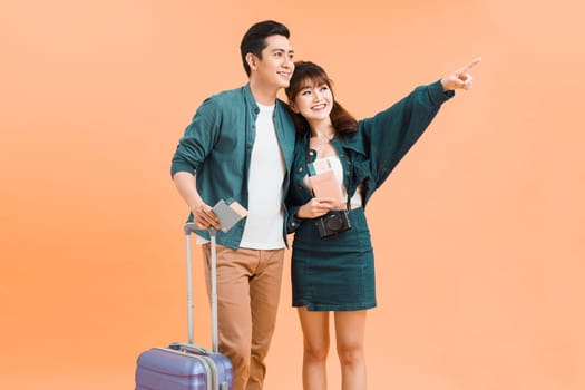 Lovely Asian couple tourists with luggage about to go for honeymoon travel isolated