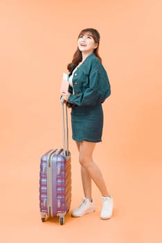 Young attractive woman tourist with a suitcase and tickets isolated 