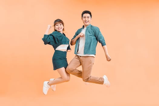 happy smiling couple isolated active jumping on color studio background,