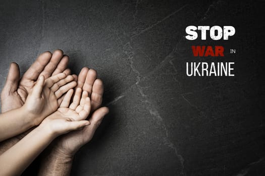 male hands hold childrens on dark marble background with words stop war in ukraine. concept needs help and support, truth will win
