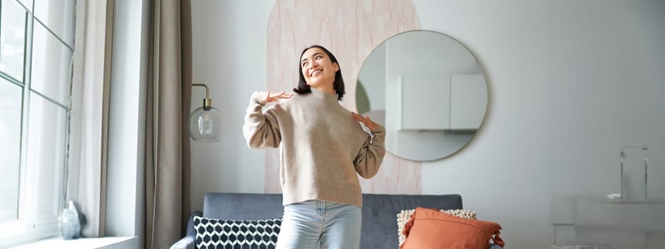 People and emotions. Joyful teen girl dancing in her room, feeling happy and carefree, concept of joy and satisfaction.