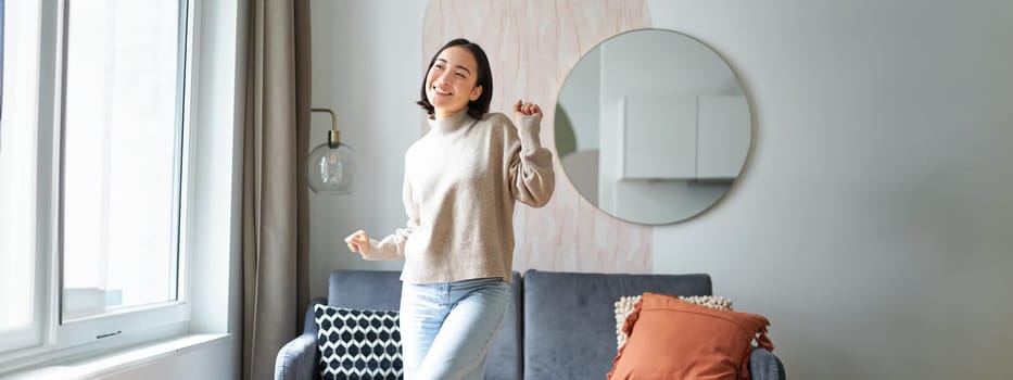 People and emotions. Joyful teen girl dancing in her room, feeling happy and carefree, concept of joy and satisfaction.