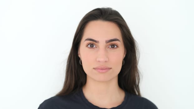 A front portrait of a confident young woman with long hair, showcasing natural beauty and simplicity.