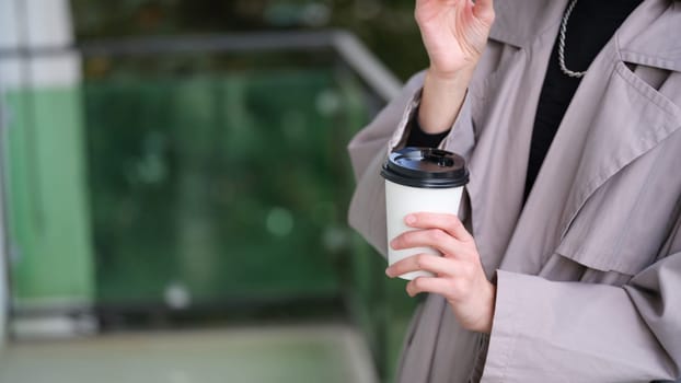 A stylish adult indulging in a cup of coffee, exuding a sense of contemporary urban sophistication and elegance