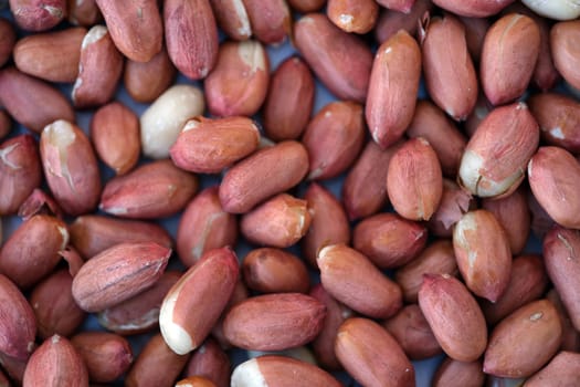 This is a detailed closeup view of raw peanuts that showcases their unique reddishbrown skin texture beautifully