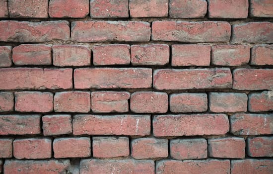 A closeup image showcasing a rustic red brick wall, which is ideal for a myriad of design and architectural projects