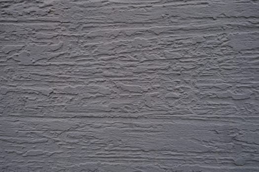 A closeup photograph of a beautifully textured gray wall that showcases intricate patterns and its depth