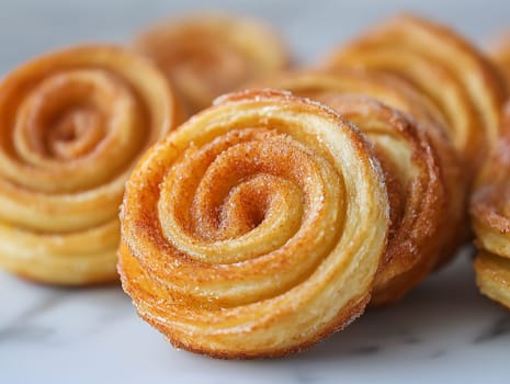 A close up of a cinnamon roll with sugar sprinkled on top. The rolls are arranged in a stack, with one of them being the largest. Concept of warmth and comfort