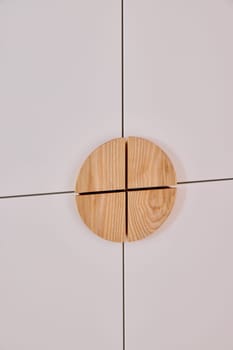 An upclose shot of a beautifully crafted circular wooden detail on a modern cabinet, emphasizing minimalist aesthetics
