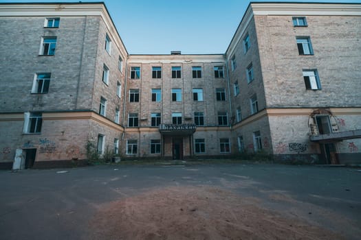 A deserted brick building with empty windows, captured at twilight, evoking a sense of decay and abandonment in an urban setting