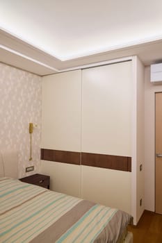 This stylish modern bedroom features an elegant builtin wardrobe and a soothing soft color palette throughout