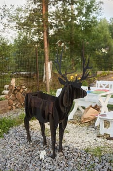 A oneofakind sculpture depicting a dog with antlers is beautifully showcased against a natural garden backdrop