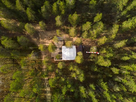 An aerial perspective beautifully showcasing a serene cabin peacefully surrounded by dense, lush greenery
