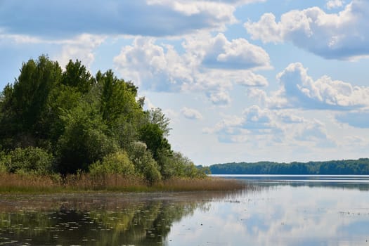 A tranquil lakeside scene showcasing lush, green trees and a vibrant, colorful sky, ideal for all nature lovers