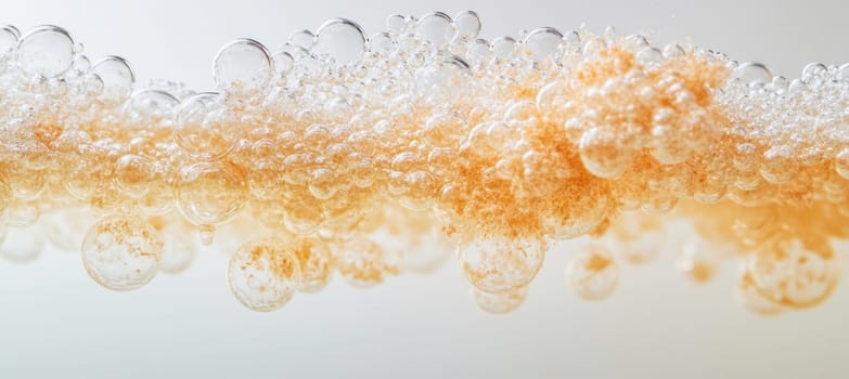 Orange particles suspended in a cluster of transparent bubbles form an abstract pattern against a light background