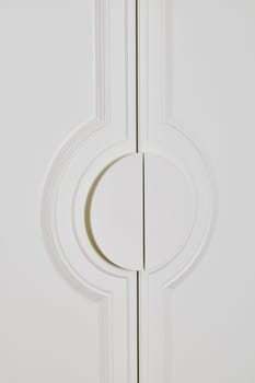 A stylish and minimalistic white door that showcases a sleek design along with a unique circular handle feature
