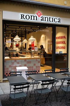 Cremona, Italy - November 20th 2024 Chefs preparing pizza alla romana inside rom antica pizzeria in cremona, italy, with outdoor tables and chairs