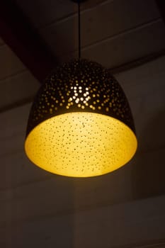 This elegant pendant light showcases a stunning intricate cutout design that creates warm, inviting lighting