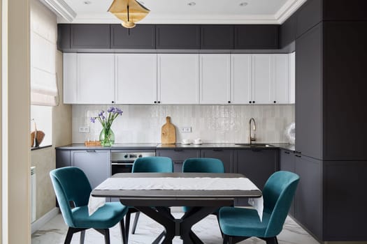 This stylish kitchen is designed with beautiful teal chairs and sleek cabinetry, creating a contemporary atmosphere