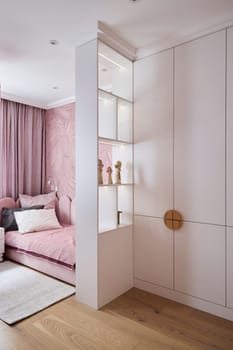 A stylish corner of your home featuring a cozy pink sofa, decorative shelves, and warm wooden flooring design