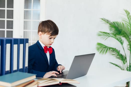 boy in business suit studying on laptop online