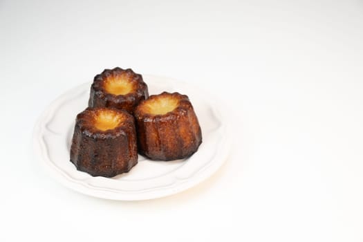 Caneles de bordeaux, traditional French sweet dessert with white table background, High quality photo
