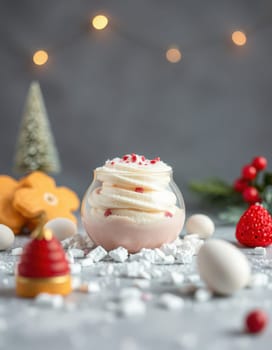 A delightful dessert is showcased in a glass jar, surrounded by festive holiday decorations, including cookies, berries, and ornaments on a winter-themed table.