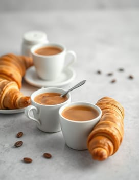 Two cups of coffee and fresh croissants are elegantly presented on a marble table, inviting a relaxing breakfast moment in a downtown setting.