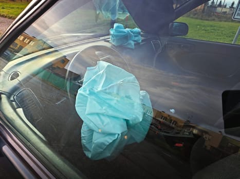 Interior of a automobile involved in a front crash with a deployed steering column airbag.