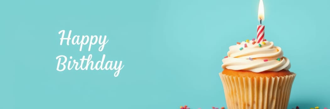 A delicious cupcake topped with smooth frosting and a lit birthday candle is surrounded by colorful sprinkles on a bright blue background. It celebrates a joyous birthday.