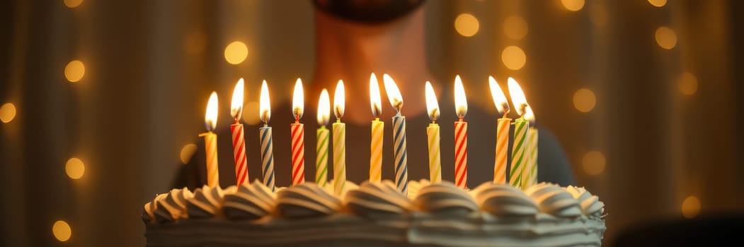 Brightly lit candles adorn a beautifully designed cake, creating a warm atmosphere for a joyful celebration surrounded by twinkling lights in the background.