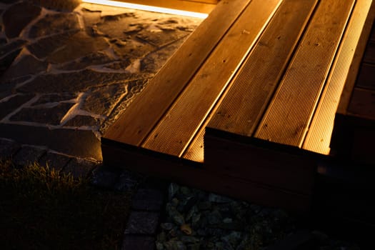 A peaceful, tranquil wooden deck beautifully showcasing soft lighting and stunning stone textures at dusk