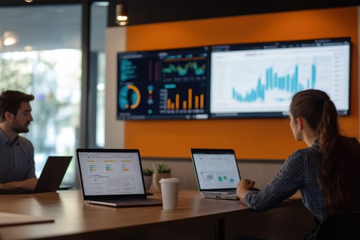 A business meeting taking place in a modern office with professionals analyzing data on screens, showcasing teamwork and productivity in a collaborative environment.