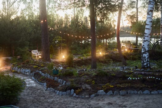 A serene garden, lit warmly at dusk, ideal for relaxation and enjoyable gatherings with friends and family