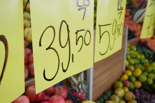 A vibrant assortment of colorful, fresh produce accompanied by price tags in a lively market scene