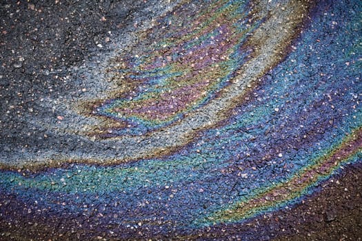Bright oil stain creating a colorful stain on asphalt.