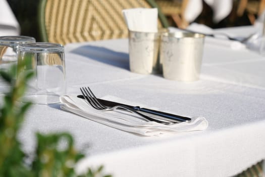 A beautifully arranged table featuring elegant silver cutlery and pristine white linens