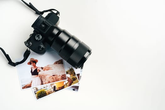 Camera and colorful printed photos of women on the desk close up