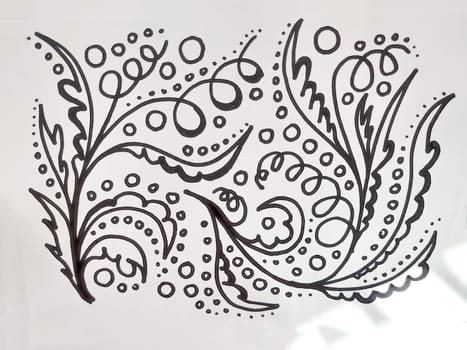 Decorative floral designs featuring swirls and dots are drawn in black ink on white paper, showcasing artistic creativity.