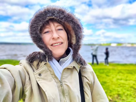 A woman, adorned in a stylish fur hooded jacket and donning a protective mask, is smiling brightly despite the circumstances