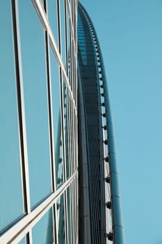 The stunning view of a remarkably modern building showcases sleek glass surfaces and a unique, bold curvature