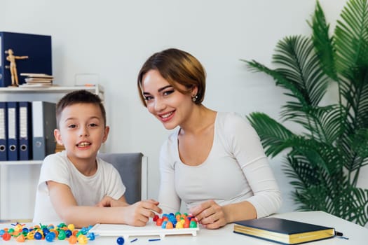 Woman Playing With Boy Educational Games On Table