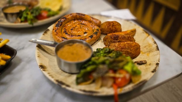 mouthwatering German worst curled up cumberland sausage meal featuring a grilled sausage, loaded cheese fries, and fresh vegetables served on a rustic plate. Perfect for dinner lovers appreciating hearty and flavorful dishes.