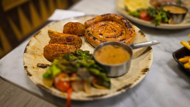 mouthwatering German worst curled up cumberland sausage meal featuring a grilled sausage, loaded cheese fries, and fresh vegetables served on a rustic plate. Perfect for dinner lovers appreciating hearty and flavorful dishes.
