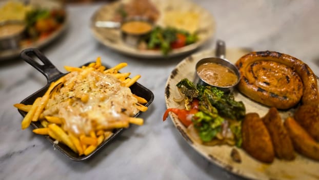 mouthwatering German worst curled up cumberland sausage meal featuring a grilled sausage, loaded cheese fries, and fresh vegetables served on a rustic plate. Perfect for dinner lovers appreciating hearty and flavorful dishes.