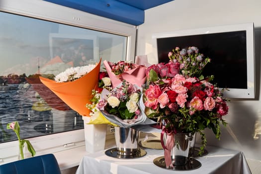 Stunning and beautiful floral bouquets are elegantly displayed in a chic indoor environment right next to a window