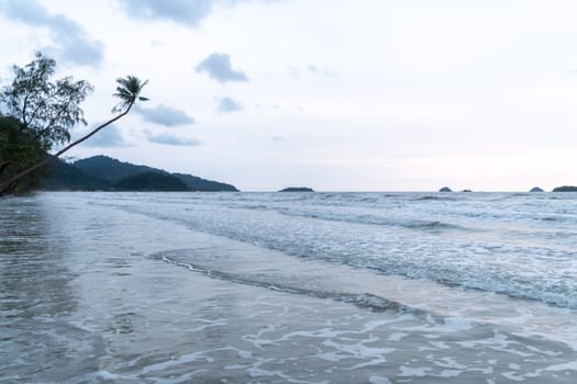 A serene and tranquil view of the seashore at dusk, featuring gentle waves and a beautiful scenic backdrop