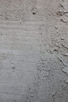 Vertical Close-up photo of old abandoned plaster on a concrete wall.