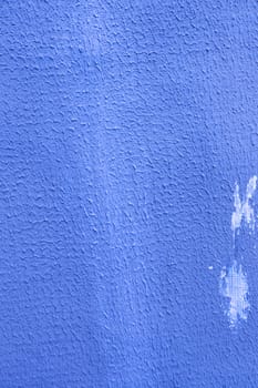 Vertical photo of blue plaster on the wall.